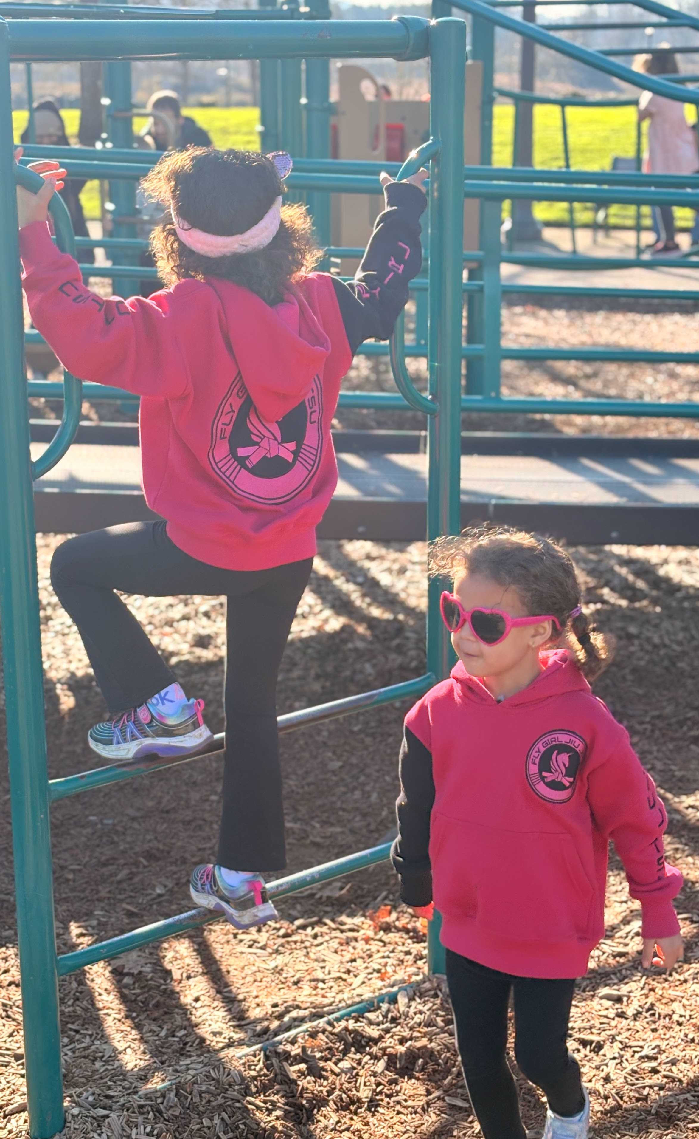 Girls in pink Fly Girl hoodies at playground